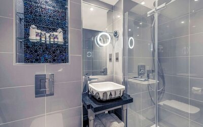 Guest bathroom with shower and free toiletries at Mercure London Hyde Park Hotel.