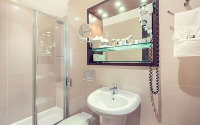 Private bathroom with tub and free toiletries at Mercure London Paddington Hotel.