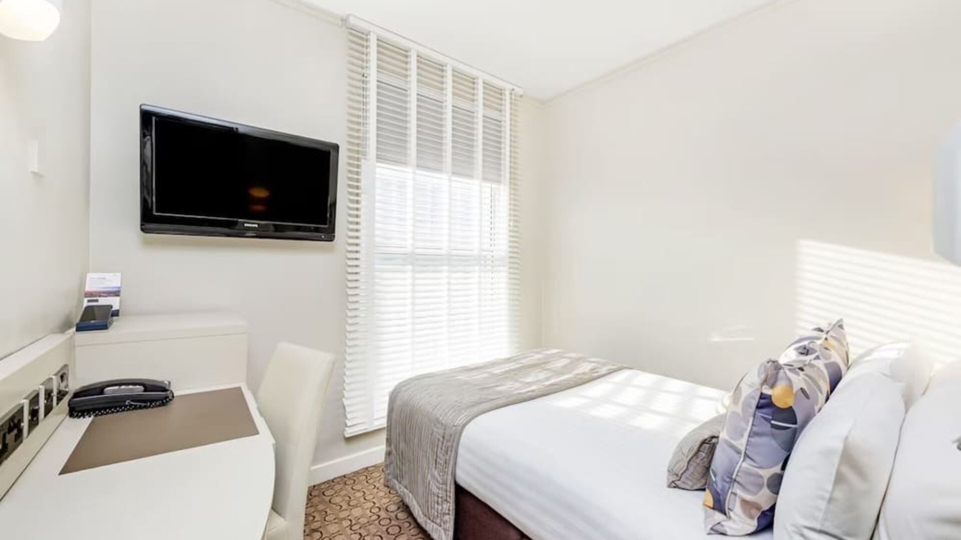 Bright day use room with TV screen, work desk and private bathroom at Mercure London Paddington Hotel.