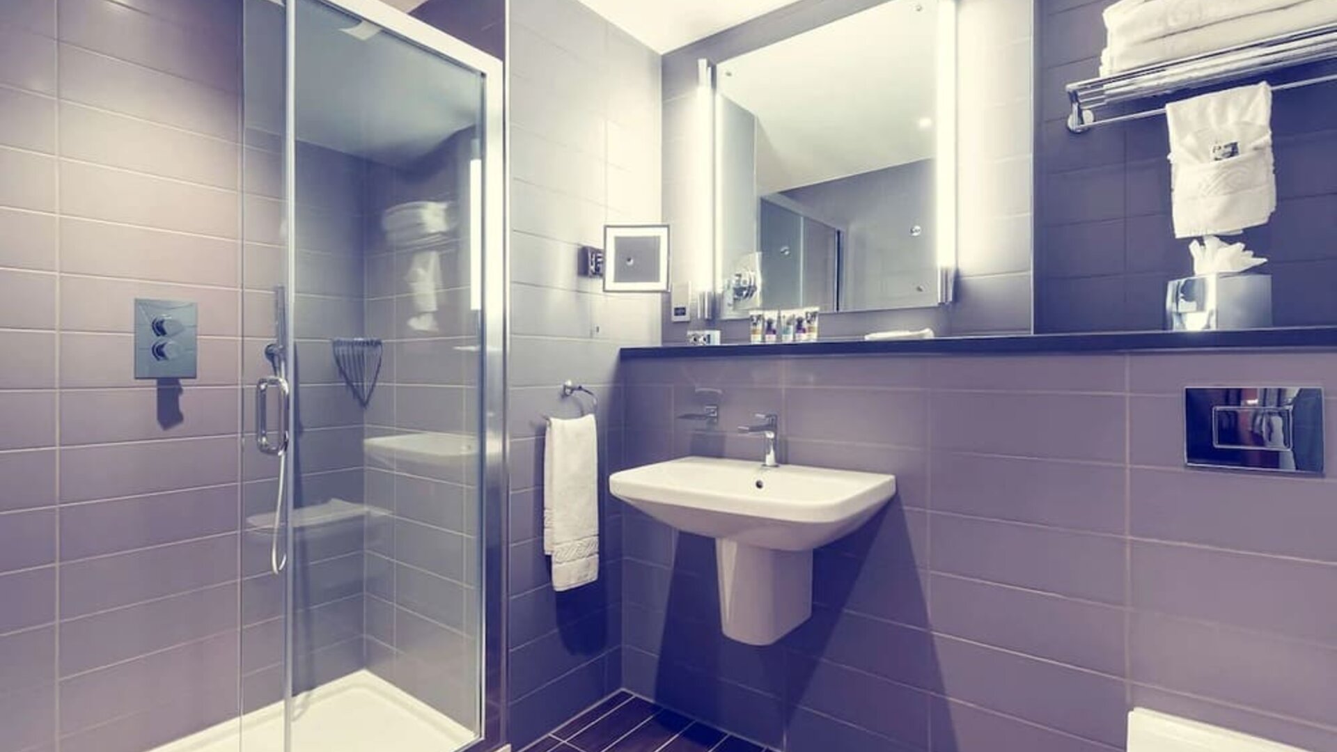 Guest bathroom with shower and free toiletries at Mercure London Paddington Hotel.
