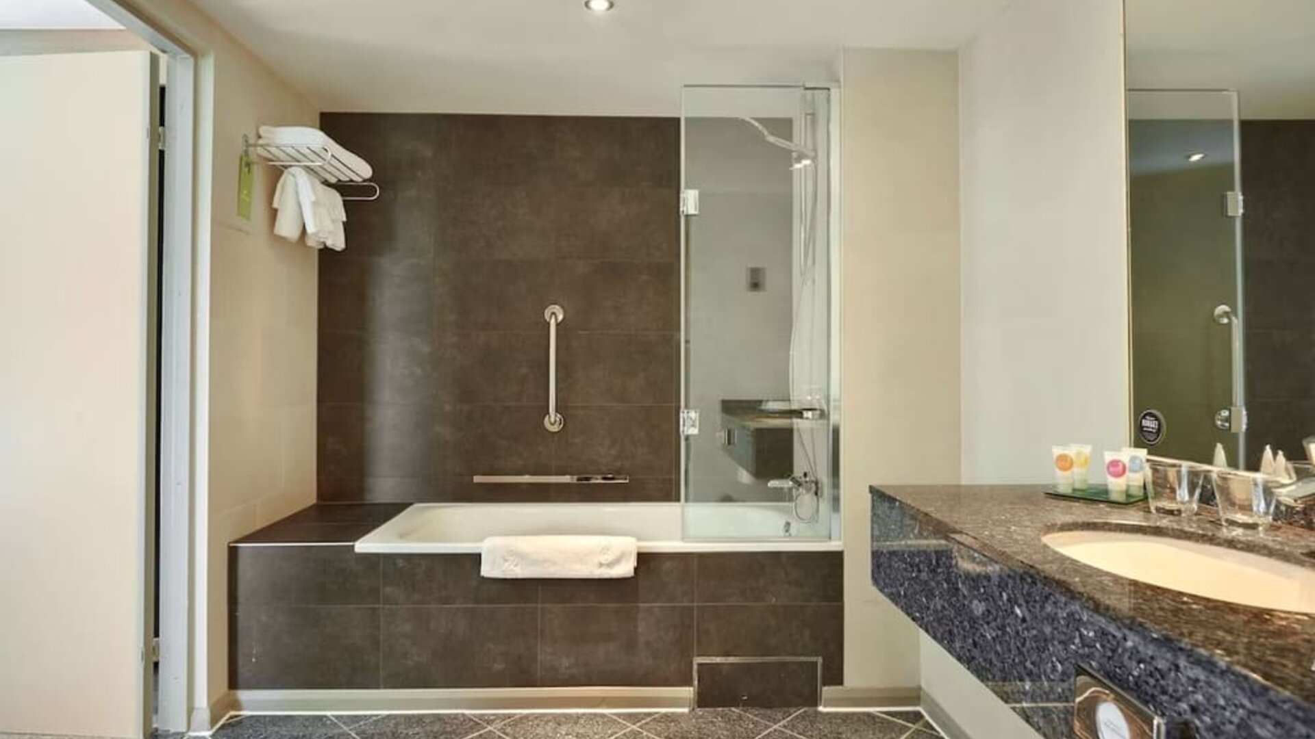Guest bathroom with combined tub and shower at Hyatt Place London Heathrow Airport. 