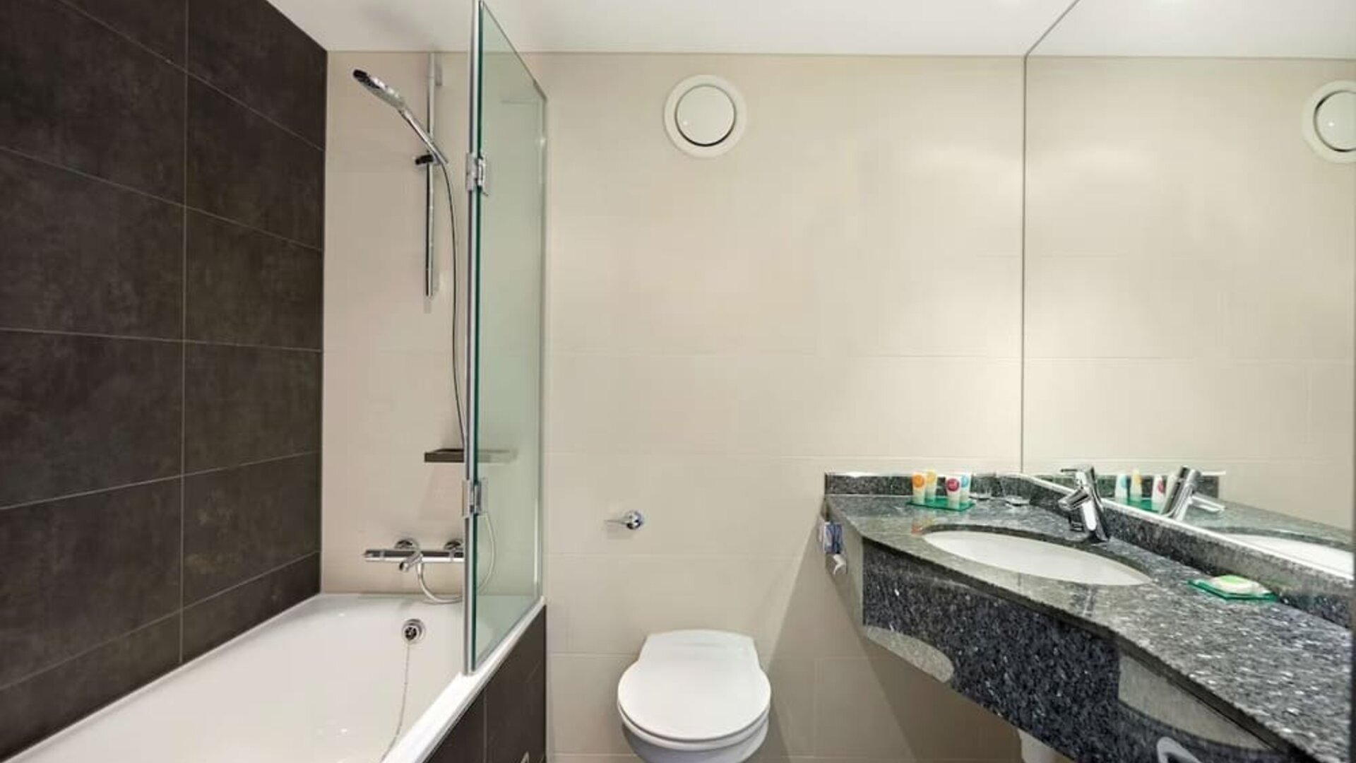 Private guest bathroom with combined tub/shower and free toiletries at Hyatt Place London Heathrow Airport.