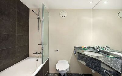 Private guest bathroom with combined tub/shower and free toiletries at Hyatt Place London Heathrow Airport.