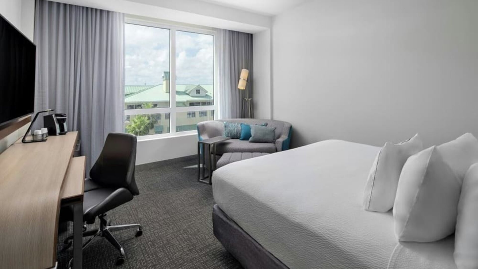 Day use room with sofa and work desk at Courtyard Delray Beach.
