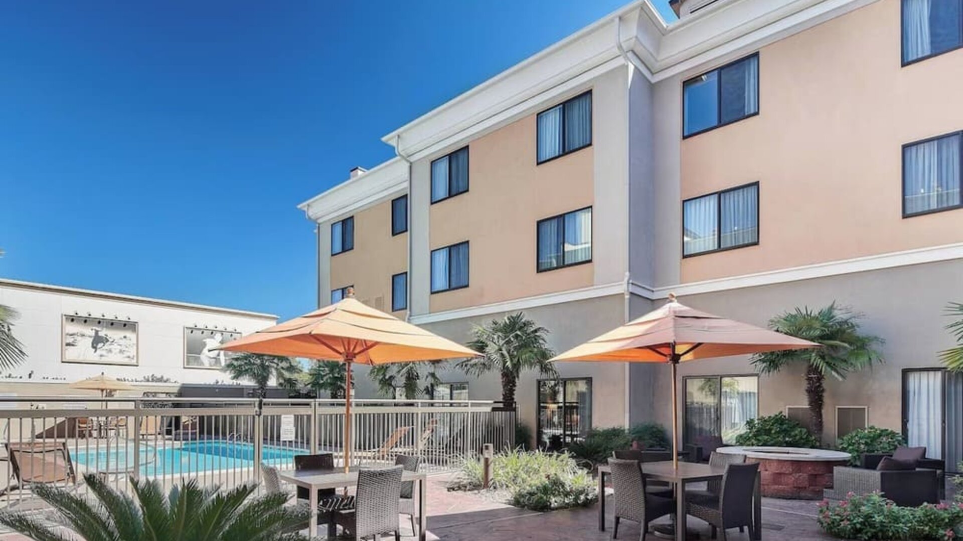 Outdoor seats available beside the pool at Courtyard Bossier City.