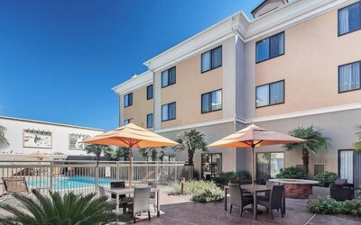 Outdoor seats available beside the pool at Courtyard Bossier City.