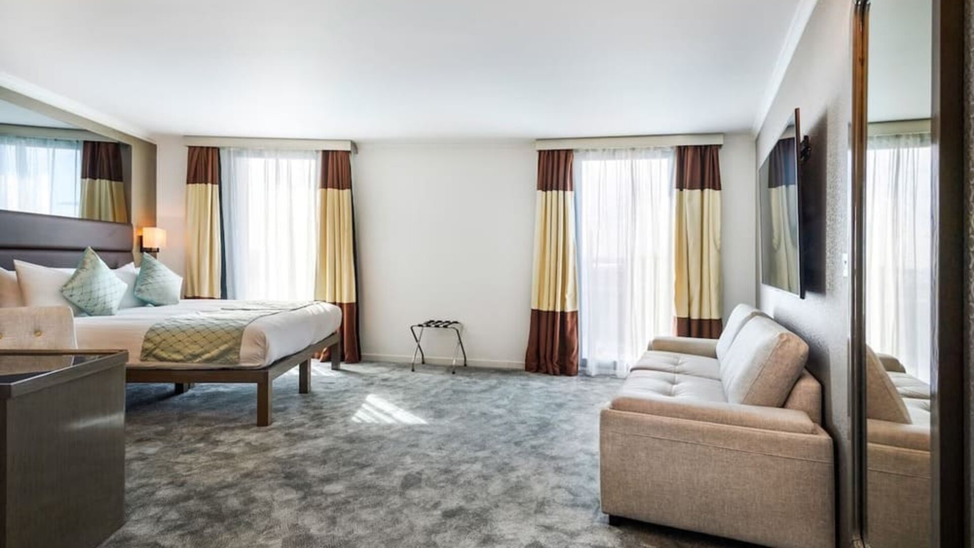 Btight and spacious king room with floor to ceiling windows, convertible sofa and work desk at Atrium Hotel Heathrow.