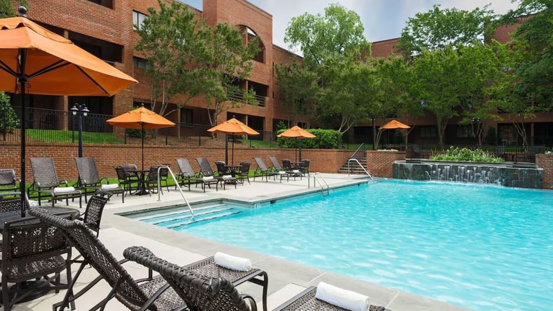 Refreshing outdoor pool with plenty of sun loungers at DoubleTree Suites By Hilton Hotel Charlotte - SouthPark.