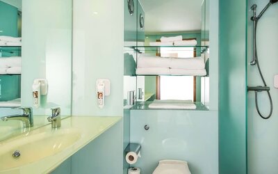 Guest bathroom with shower and free toiletries at ibis Styles Birmingham NEC.