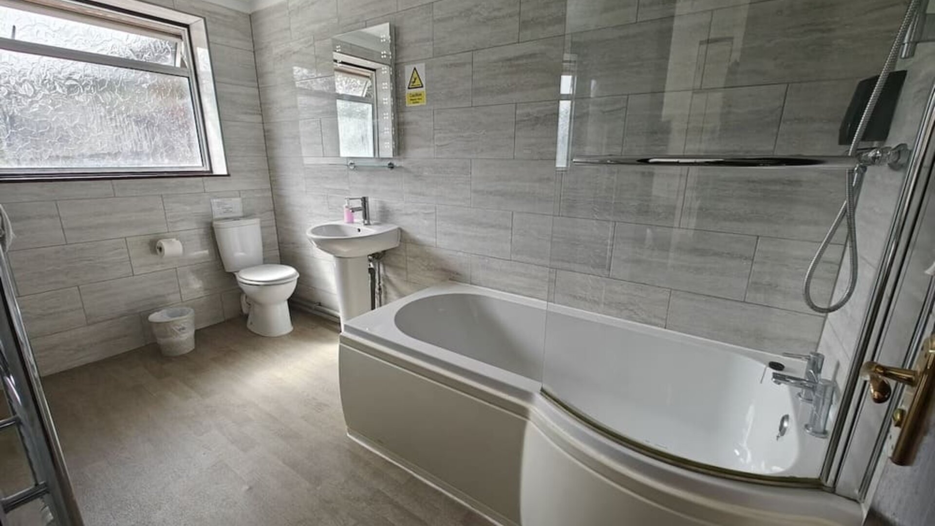 Guest bathroom with combined tub and shower at Little Foxes Hotel.