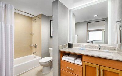 Guest bathroom with shower and tub at Hyatt HOUSE Fort Lauderdale Airport-South & Cruise Port.
