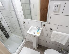 Private guest bathroom with shower and free toiletries at Trivelles Seaforth Hotel.