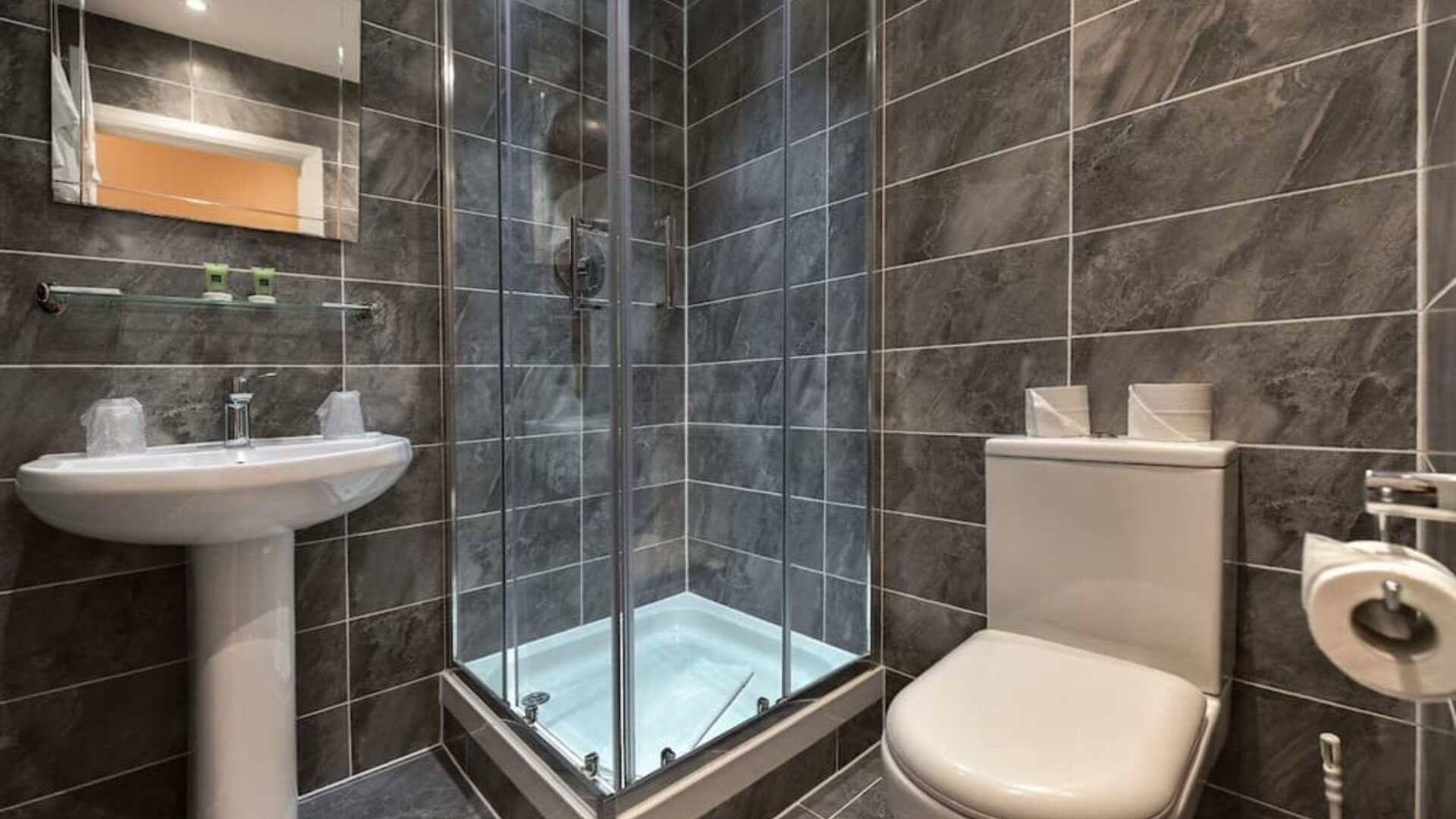 Guest bathroom with shower and free toiletries at The Bayswater Inn Hotel.
