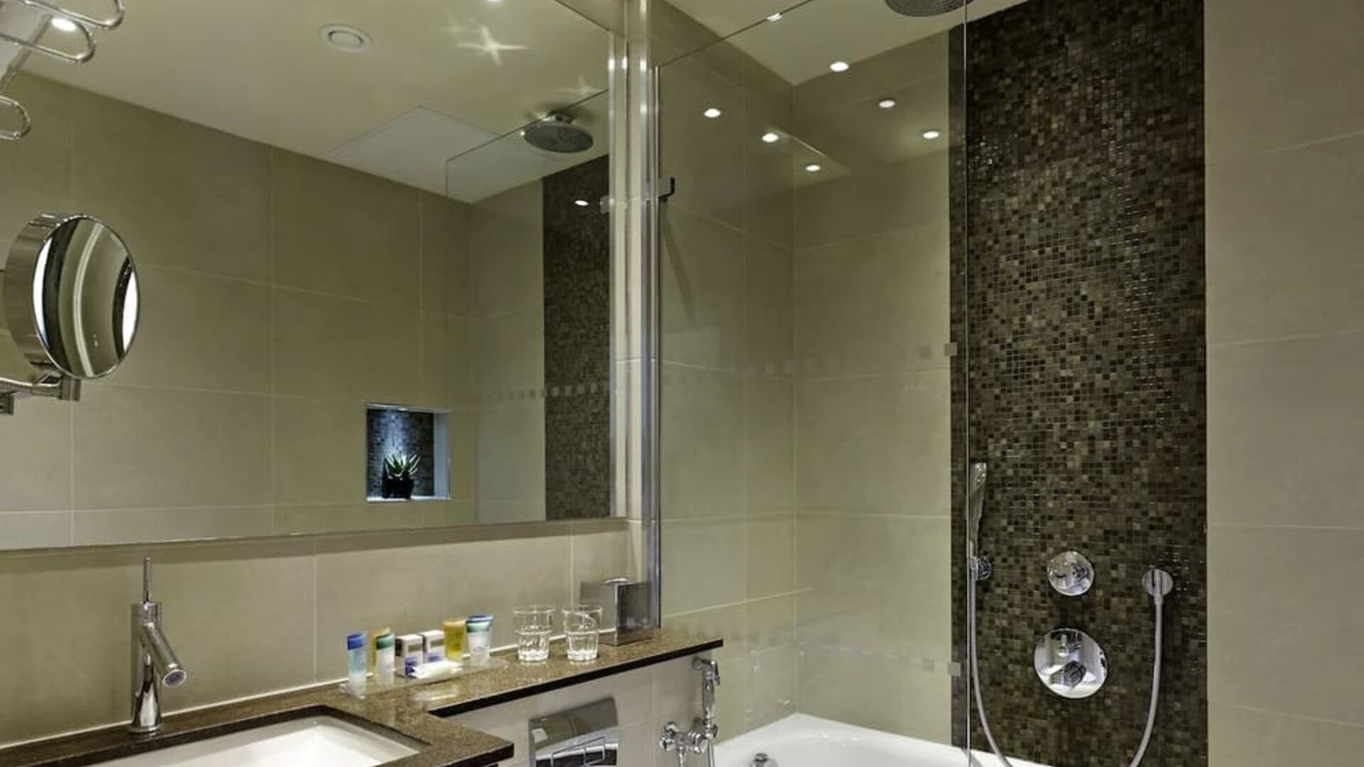 Guest bathroom with combined tub and shower at Blakemore Hyde Park Hotel.