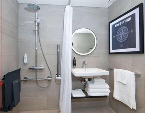 Private guest bathroom with shower at Ibis London Gatwick Airport Hotel. 