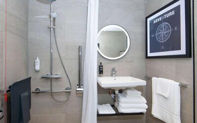 Private guest bathroom with shower at Ibis London Gatwick Airport Hotel. 