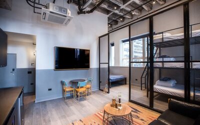 Day use room with three tier lofted bed, large living space and kitchenette at The Chicago Hotel Collection River North.