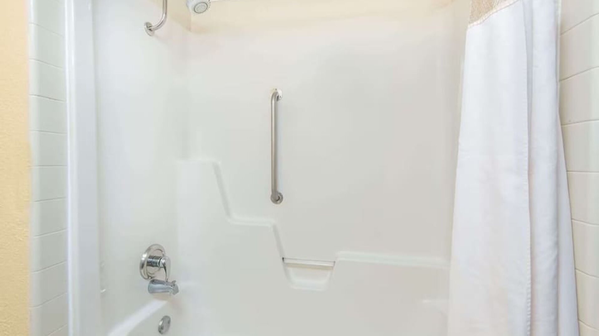 Guest bathroom with shower and tub at Blue Way Inn & Suites Wichita East.
