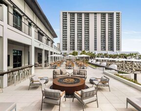 Firepit and plenty of outdoor seats near pool area at Embassy Suites By Hilton Myrtle Beach Oceanfront Resort.
