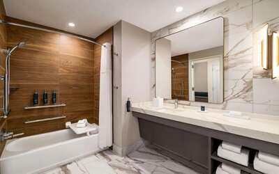 Private guest bathroom with tub at Hilton BNA Nashville Airport Terminal.
