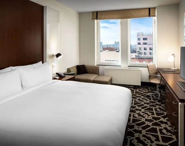 Day use room with work desk and lounge seating at Hilton Brooklyn New York.