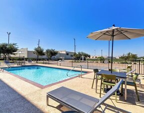 Relaxing outdoor pool with lounge chairs at Spark By Hilton Pearland.