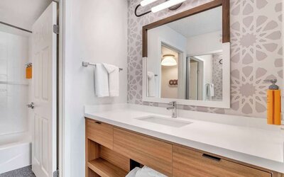 Private guest bathroom with shower and free toiletries at Sonesta ES Suites San Antonio Downtown Alamo Plaza.