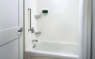 Private guest bathroom with tub and free toiletries at Sonesta ES Suites Raleigh Cary.