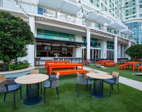 Alfresco dining and lounge area beside a bar at Hilton Orlando.