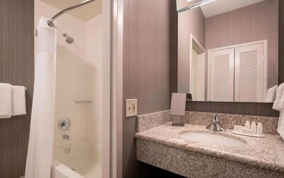 Private guest bathroom with shower and free toiletries at Sonesta Select Tempe Downtown.