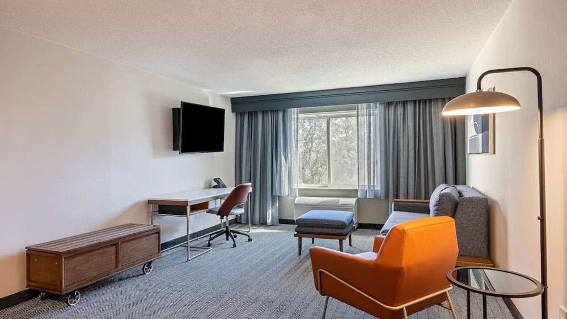 Day use deluxe room's living area with work desk and comfortable seating at Sonesta Select Pleasant Hill.