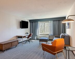 Day use deluxe room's living area with work desk and comfortable seating at Sonesta Select Pleasant Hill.