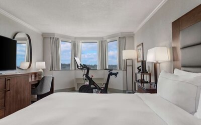 Day use room with work desk and Peloton bike at Hilton Crystal City At Washington Reagan National Airport.