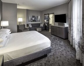 King size bed and sofa in a day use room at DoubleTree By Hilton Modesto.