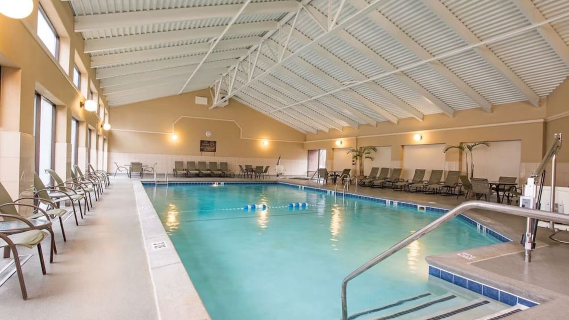 Refreshing indoor pool surrounded by loungers at DoubleTree By Hilton Grand Rapids Airport.