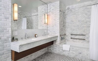 Private guest bathroom with combined shower and tub at Nautilus Sonesta Miami Beach.
