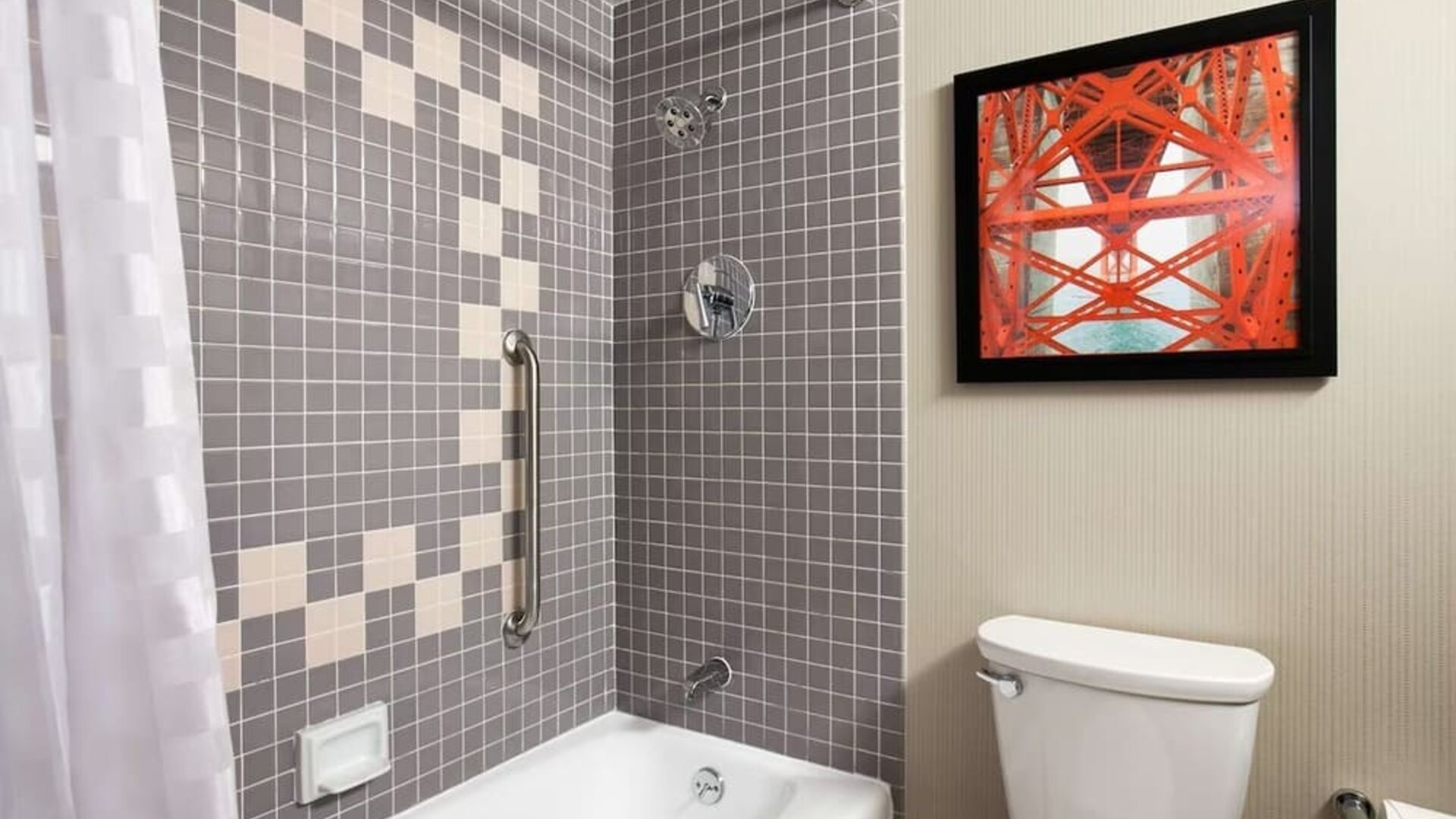 Guest bathroom with shower and tub at Embassy Suites By Hilton San Francisco Airport Waterfront.