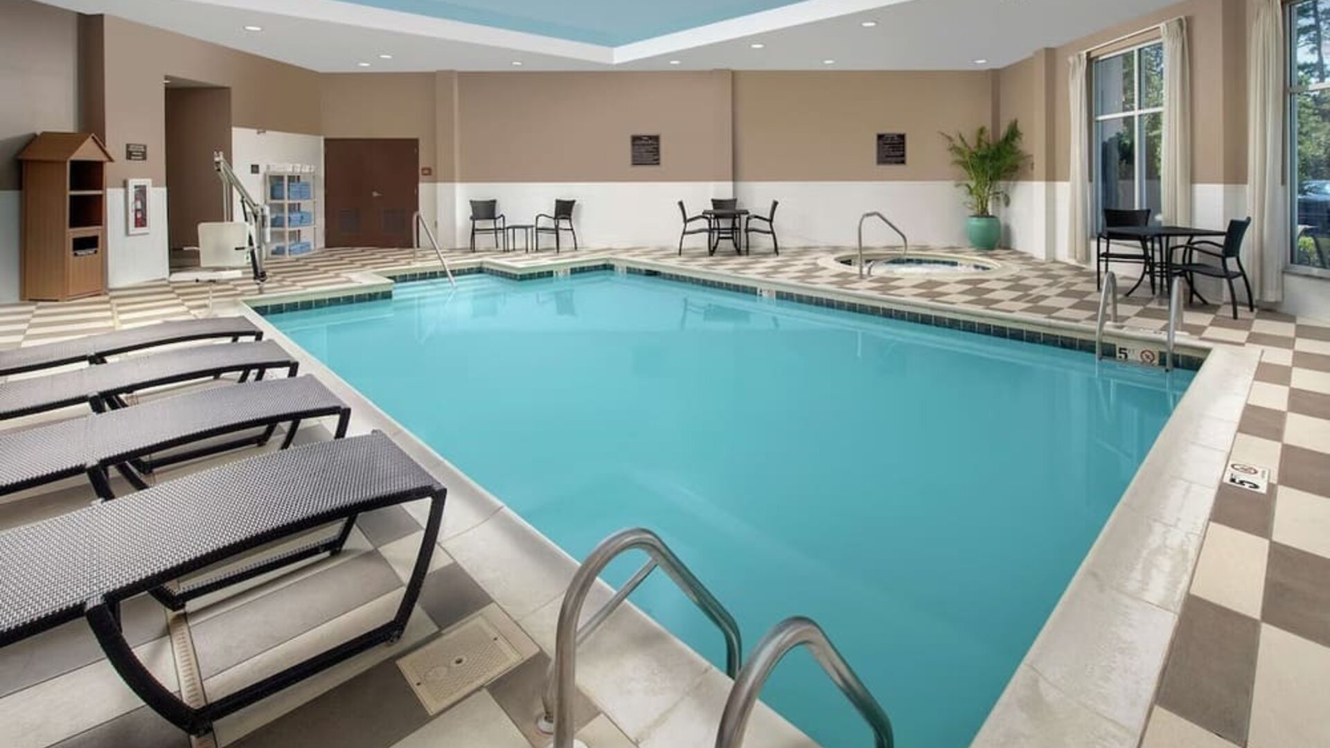 Refreshing indoor pool with loungers at Embassy Suites By Hilton Birmingham.