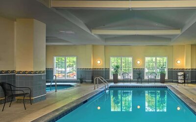 Indoor pool with lounge chairs at Sonesta Atlanta Airport South.