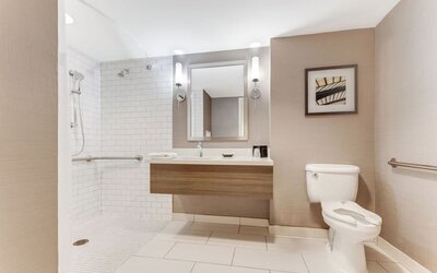 Private guest bathroom with shower and free toiletries at Sonesta Anaheim Resort Area.