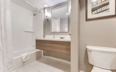 Private guest bathroom with combined shower and tub at Sonesta Anaheim Resort Area.
