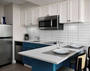 In-room kitchen, equipped with microwave, fridge, sink and breakfast bar at Sonesta ES Suites Chicago Downtown Magnificent Mile - Medical.
