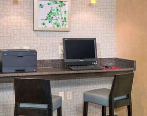 Business center with computer, printer and comfortable chairs at Sonesta ES Suites Charlottesville University.