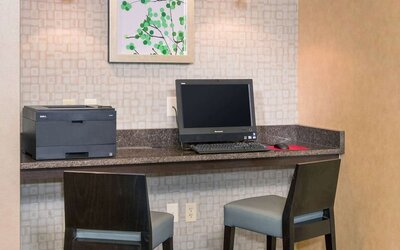 Business center with computer, printer and comfortable chairs at Sonesta ES Suites Charlottesville University.