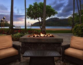 Hotel terrace with lounge seating and fire pit at Royal Sonesta Kaua'i Resort Lihue.