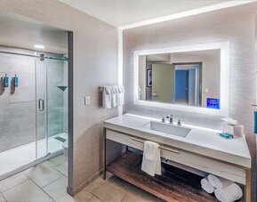 Guest bathroom with shower at DoubleTree By Hilton Tulsa-Downtown.
