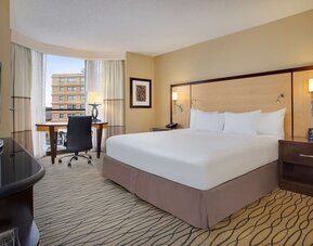 Spacious king room with TV and work area ideal for working remotely at Hilton Rosemont/Chicago O'Hare.