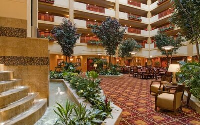 Spacious lobby and coworking lounge with natural light at Embassy Suites By Hilton Hampton Convention Center.