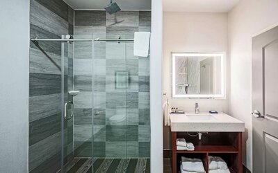 Guest bathroom with shower at The Leo Collection, An Ascend Collection Hotel.