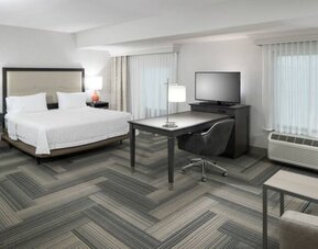 King bed with work desk and living area at Hampton Inn & Suites By Hilton Atlanta Perimeter Dunwoody.